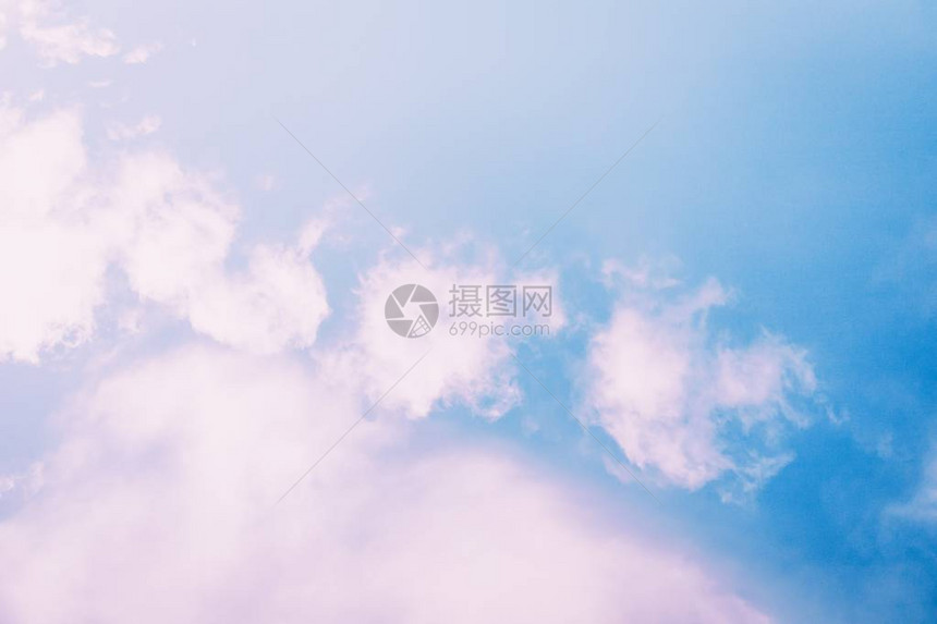 在蓝天背景的蓬松浅粉色云彩图片