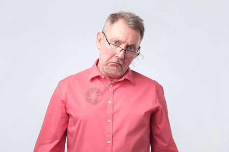 穿着红衬衫和眼镜的老人对他的养老金数额之大感到不快和痛苦图片