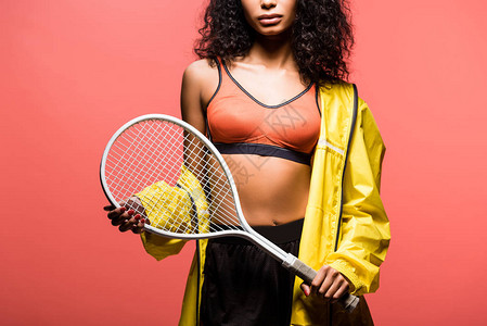 以珊瑚为孤立位置的网球拍手的非裔美国女运动图片