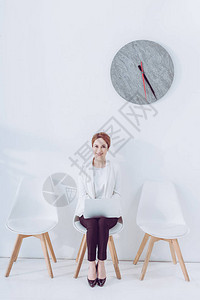 在等待工作面试时坐在膝上型电脑椅子上图片