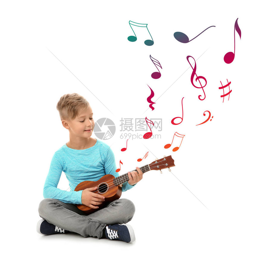 小男孩玩吉他和飞行音乐笔记图片