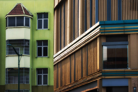现代建筑和清晨日出与旧绿色建筑相对比图片
