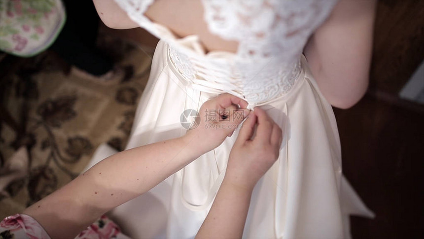 妈帮新娘穿上婚纱库存手系婚纱的紧身胸衣图片