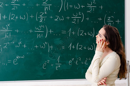 黑板前的年轻女数学老师图片