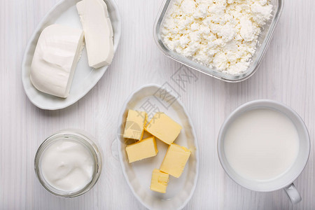 白色木制背景上的不同类型的乳制品牛奶干酪软奶酪酸奶图片