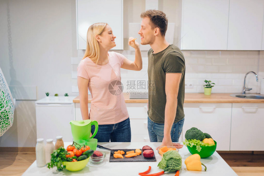 素食主义者的年轻女子早上给她丈夫切一块生蔬菜爱家人在里烹饪有机蔬菜饮食排毒生图片