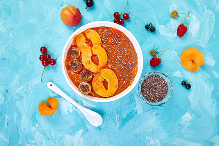 蓝色背景的健康的早餐碗黑莓和辣椒种子的杏仁香水维冈食物平面布图片