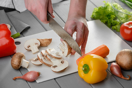 厨师用桑托库刀切玉米蘑菇在厨房图片