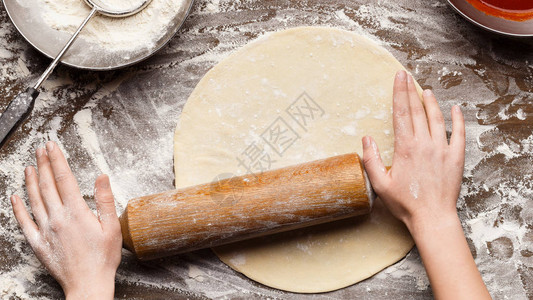 妇女为披萨准备面粉面粉图片
