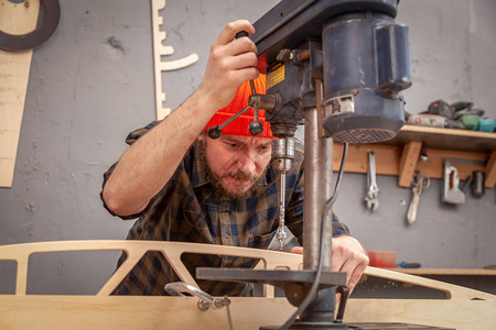 木匠用电钻在木板上钻孔木钻手在木板上钻孔图片