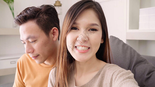 亚洲夫妇在家与朋友使用智能手机视频通话图片