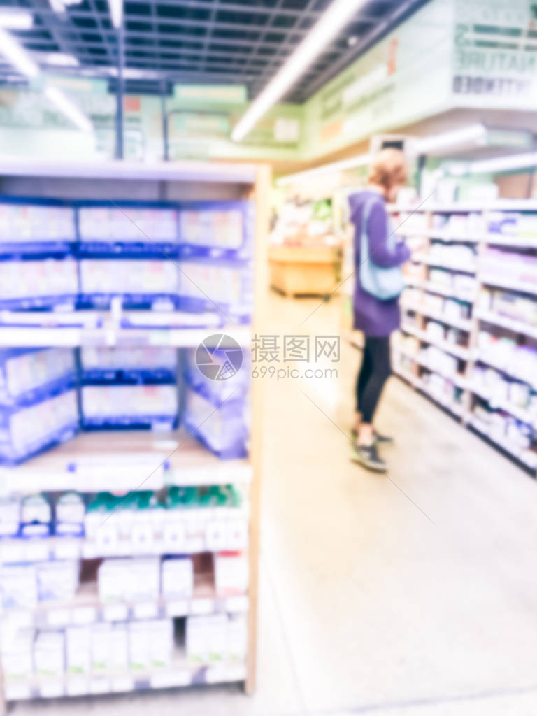 一个瘦的女人在当地药店购物时从货架上寻找补充产品的动作模糊保健药品买家客户图片