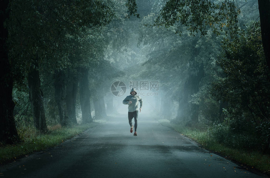 在雾的清晨一个人在空路上跑图片