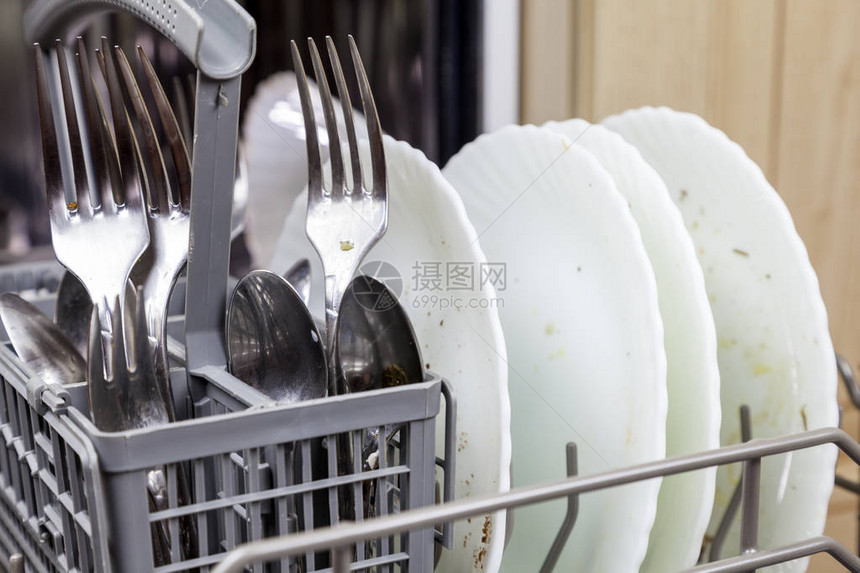 家庭厨房里有脏盘子的开放式洗碗机图片