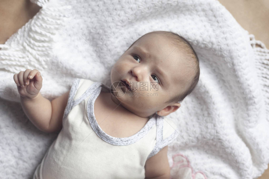 2个月男婴说谎两个月大的可爱的新生男婴在柔软的纺织品上的特写镜头可爱的孩子在玩图片