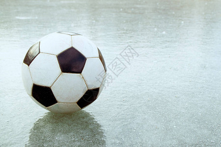 在薄冰上是一支橄榄球飞出田地在冷图片