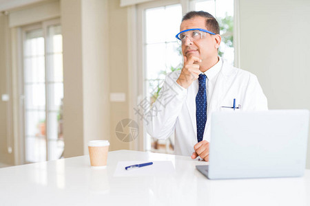 身戴专业眼镜的中年科学家男子使用笔记本电脑工作严肃地面对问题思考图片