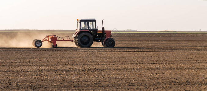 农田用拖拉机播种作物的农民图片