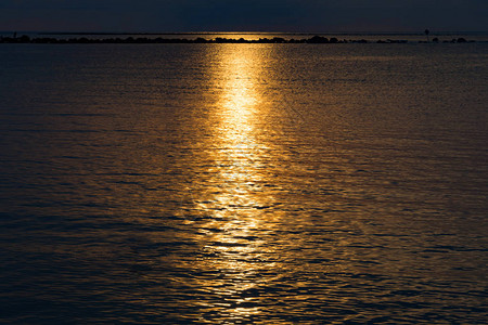 日落的天空在海中反射日落的光图片