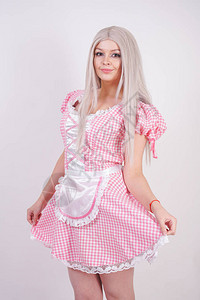 身穿粉色格子巴伐利亚连衣裙围裙摆在白色工作室纯色背景上的背景图片