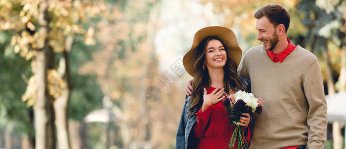 欢乐的男人看着戴帽子的女友笑着微笑图片