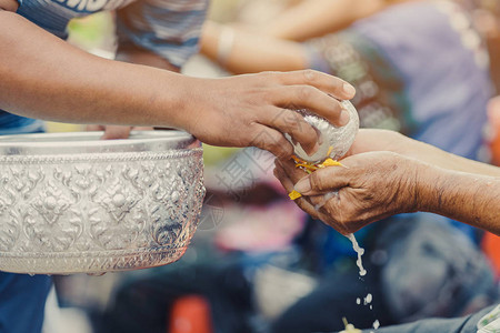 拎水桶志愿者泰国人通过浇水和花环给长辈或尊敬的祖父母和长辈庆祝泼水节背景