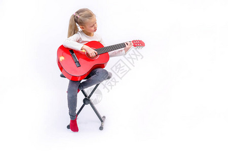 金发女孩坐着弹红色吉他图片