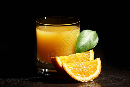 深色背景中的一杯新鲜橙汁图片