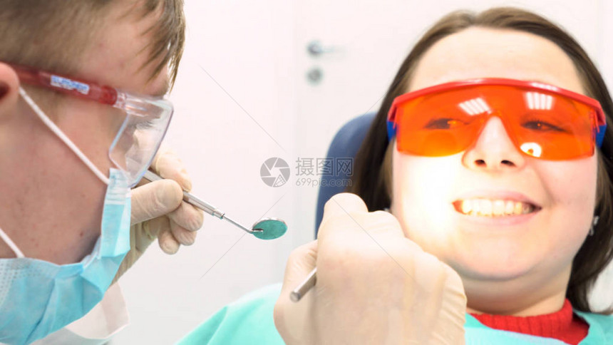 牙科护理概念媒体一个戴防护眼镜的小女孩在看牙图片