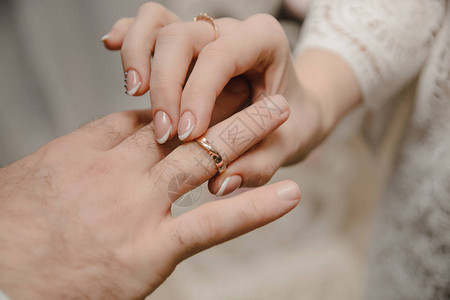 新娘把戒指戴在新郎的手指上婚礼当天图片