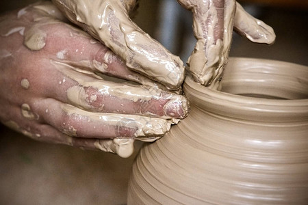 宏宇陶瓷手中的粘土宏制作瓦罐粗湿特写男人手制作粘土壶宏车间里的雕塑家用陶器特写做了一个壶花瓶白粘背景