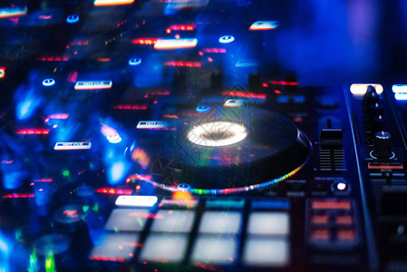 在夜总会混合有彩色效果的音乐的专业DJ图片