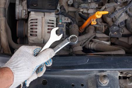 在车间用扳手修理汽车发动机的械师汽车服务维修保图片