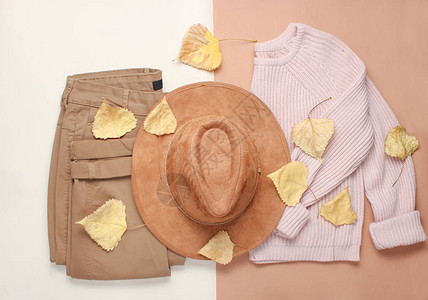 米色背景上的女装和配饰时尚的毛衣裤子毡帽在落黄的树叶间秋季衣橱图片