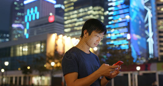 男人晚上在城市看手机图片