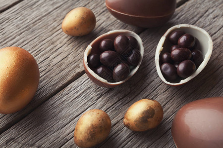 木制背景上的巧克力复活节彩蛋和糖果球图片