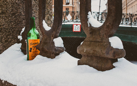 栏杆上雪地里的波特酒瓶图片
