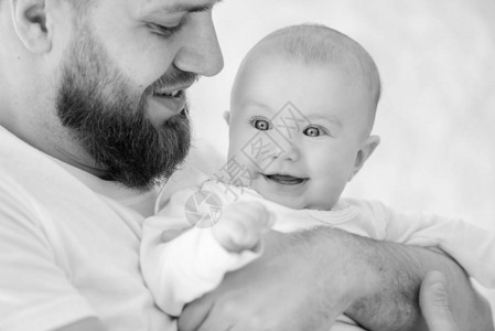 留胡子的男人把婴儿幸福的家庭放在室图片