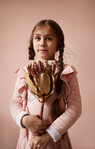 可爱小女孩的肖像拿着干鲜花图片