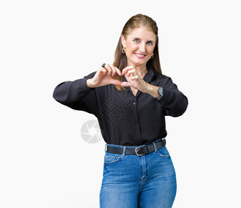 美丽的中年成熟女商人在孤立的背景下微笑着用双手展示心脏符号和形状图片