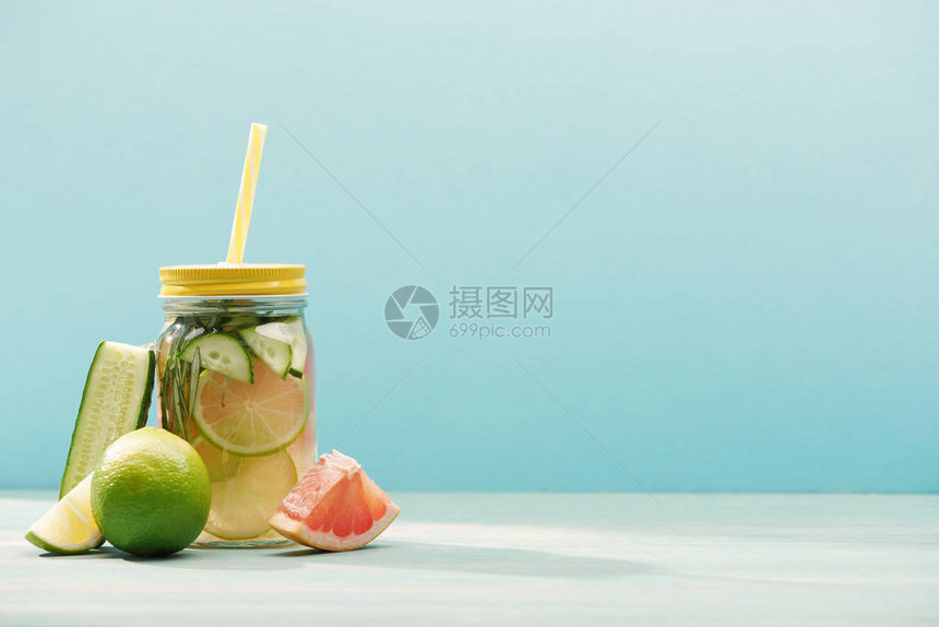 在青蓝孤立的石灰黄瓜和葡萄油附近的罐子中图片