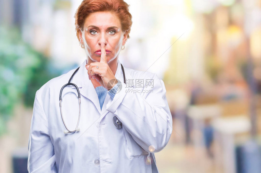 身穿医疗制服的白人高级女医生在与世隔绝的背景下要求保持安静图片