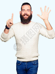 穿着冬季毛衣的嬉皮士年轻男子带着6号手指举起手来微笑着自图片