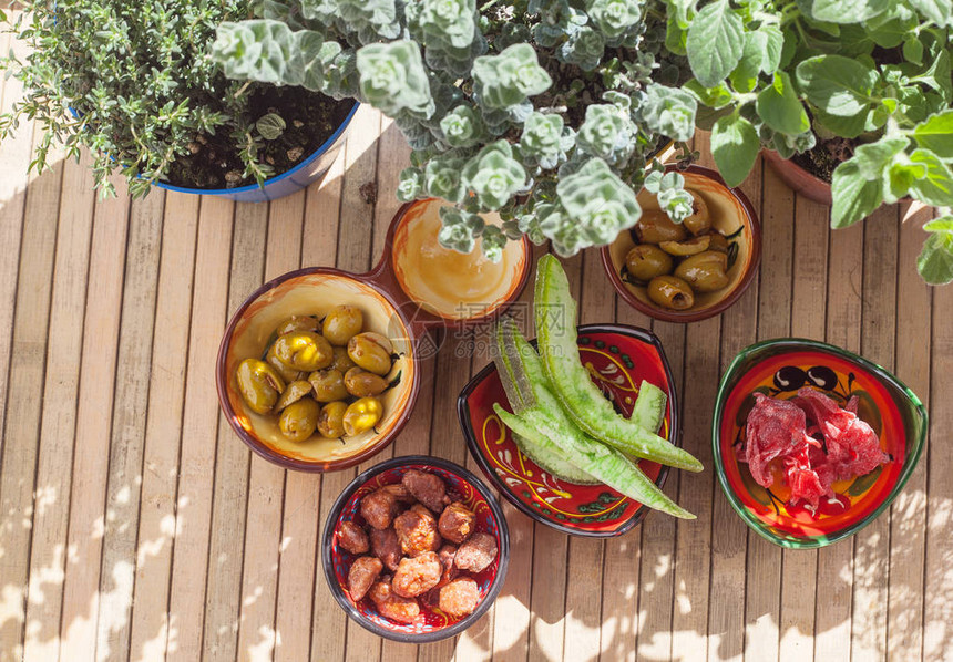 葡萄果和罐头花辣橄榄焦糖杏仁以及周围光和阴影中的芳香植物安达卢西亚产品图片