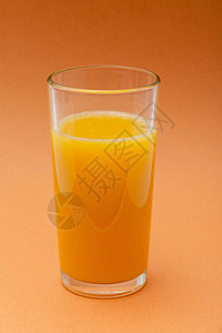 橙色背景中的一杯橙汁图片