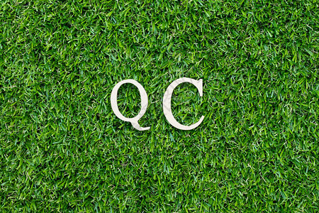绿色草本上以字母QC质量控制缩写表示背景图片