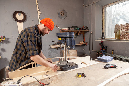 关闭在工作服雕刻木头的木匠在钻子手工作DIY灵感改进工作修理店头盔细木工创业理念工业教育背景图片