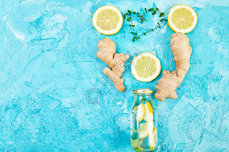 时尚排毒健康饮品在蓝色背景的成分生姜柠檬薄荷的瓶子里排毒夏季饮料图片