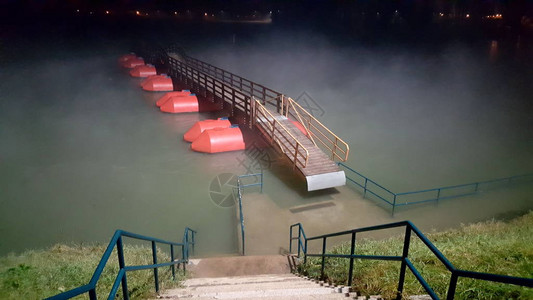 在洪涝期间夜被雾包围的木制浮舟桥的步行通道图片