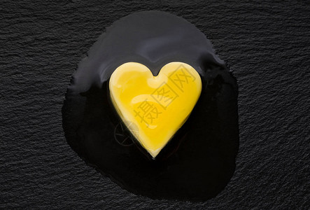 黑锅上熔化的心形黄油片高胆图片